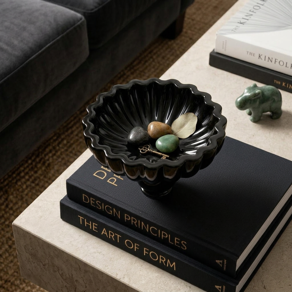 Bloom Bowl in glossy black on a stack of books